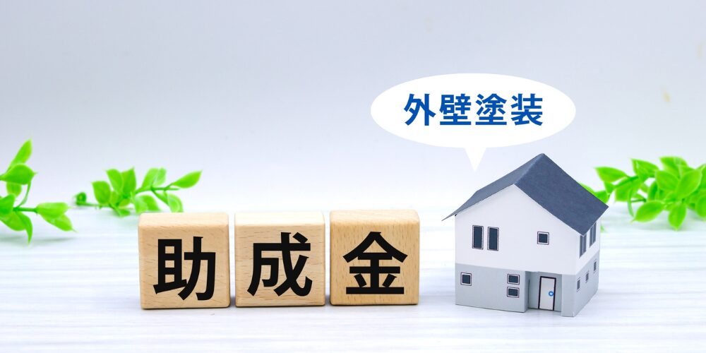 外壁塗装の助成金をイメージした木製ブロックとミニチュア住宅の写真