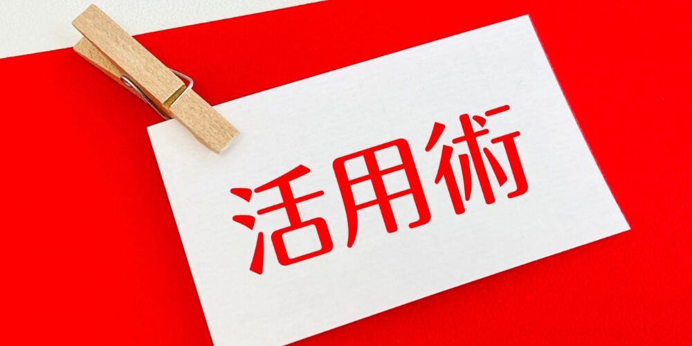 赤い背景に木製クリップで留められた『活用術』と書かれたカードの画像