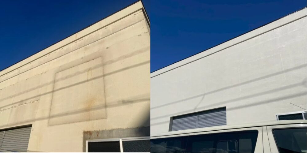 青空を背景に、左側が汚れや錆のあるクリーム色の倉庫外壁、右側が同じ角度で塗装を終えた白くきれいな外壁になったビフォー/アフター写真。