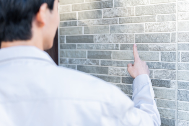 外壁をチェックする作業員