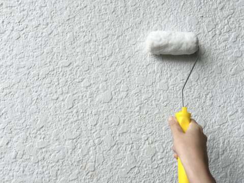 ローラーを壁に当てている画像