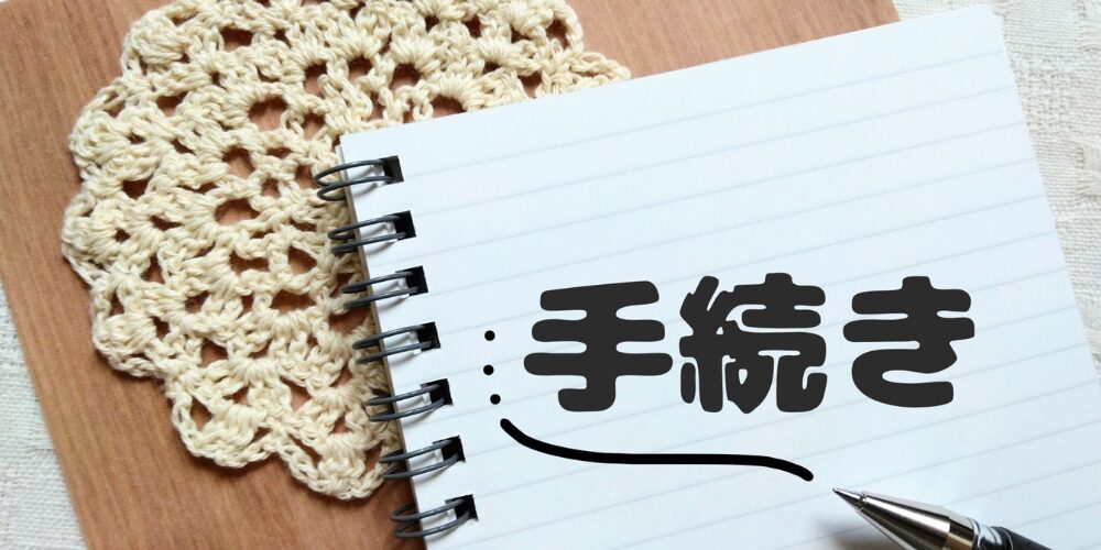 レース編み敷物の上のノートに『手続き』と書かれている画像