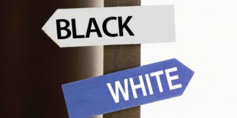 ：黒い壁に取り付けられた「BLACK」と「WHITE」の矢印プレートが左右に分かれている