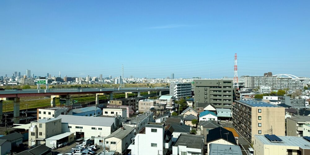 高架道路と住宅街を見渡す青空の都市景観の画像