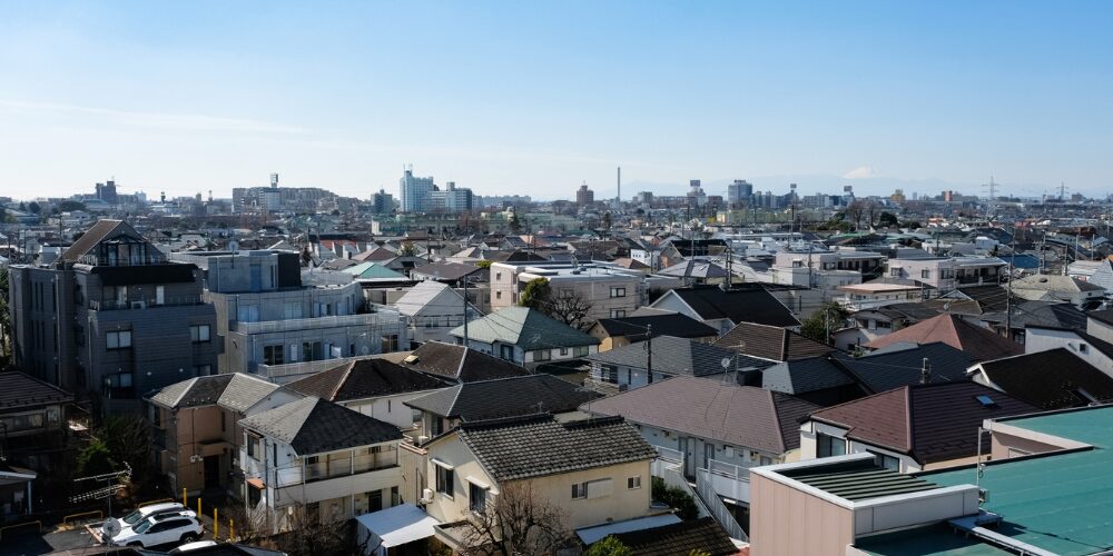 住宅街の屋根が広がり、遠景に富士山を望む晴天の街並みパノラマ