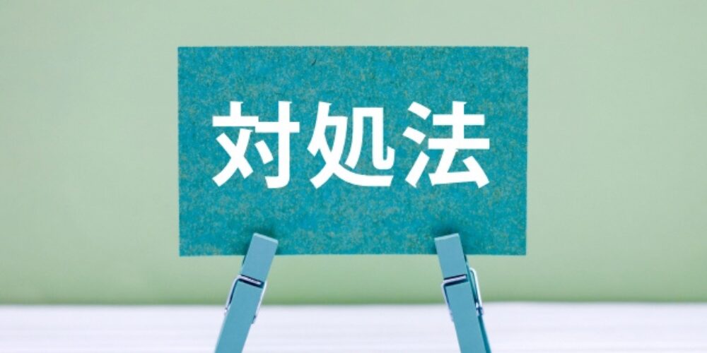 洗濯ばさみで支えられた緑色の紙に「対処法」と書かれている