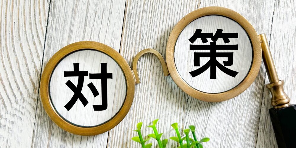 丸眼鏡のレンズに『対』『策』の文字が映し出されている画像
