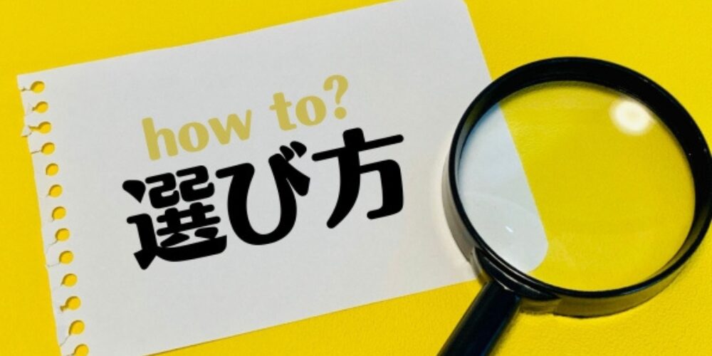 黄色の背景に「how to? 選び方」と書かれた紙と拡大鏡