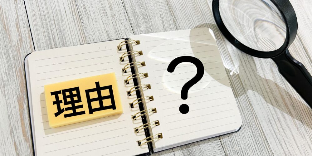 ノートの左ページに「理由」と書かれた付箋、右ページに大きな「?」が描かれ、横に拡大鏡が置かれた、選択理由を問いかけるビジュアル。