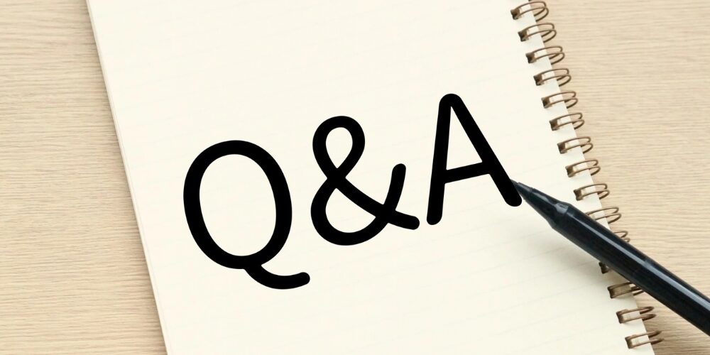 ノートに手書きされた『Q&A』の文字とボールペンのクローズアップ写真