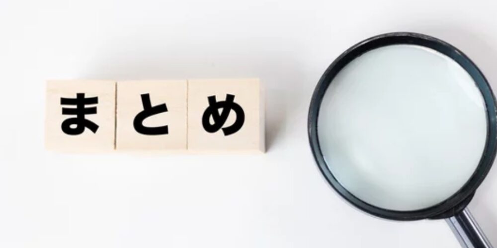 白い背景に並べられた「まとめ」の文字ブロックと、その右側に置かれた虫眼鏡