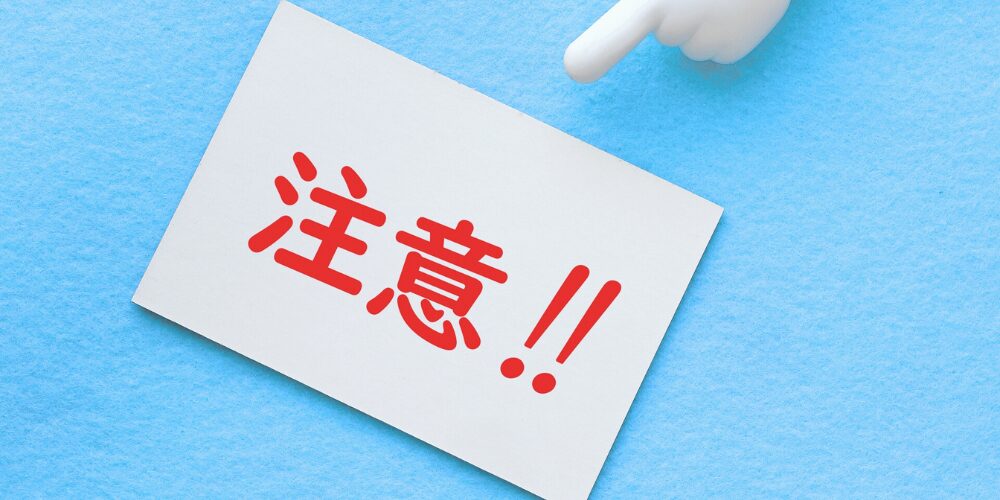 水色背景に白いカードに赤字で「注意!!」と書かれ、上方から人差し指のマスコットが指し示す構図。