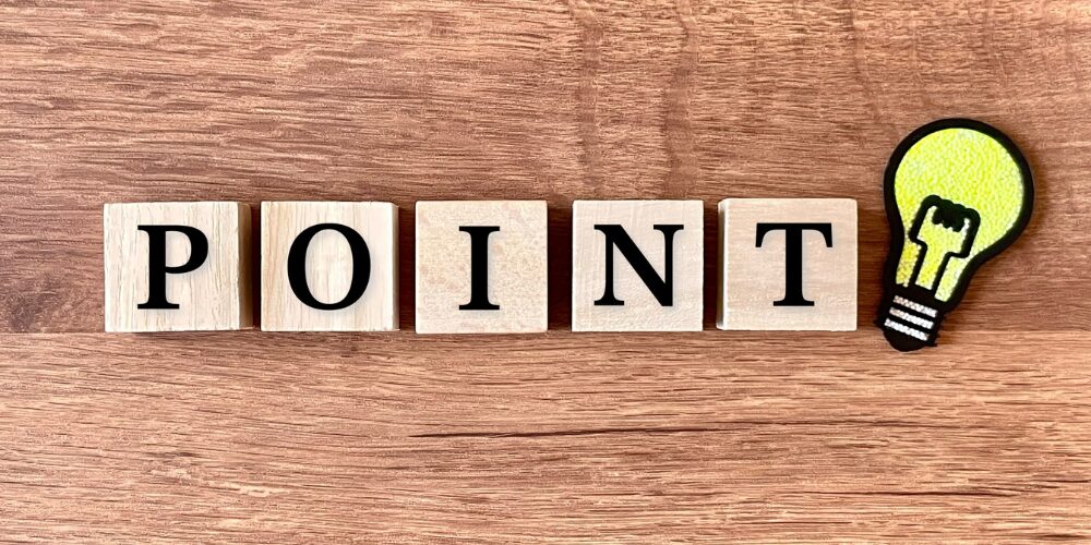 木製のブロックで「POINT」と並べ、その横に黄色い電球のイラストが置かれた写真。