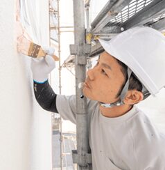 塗装作業をしている株式会社ペインティアホームズのスタッフ